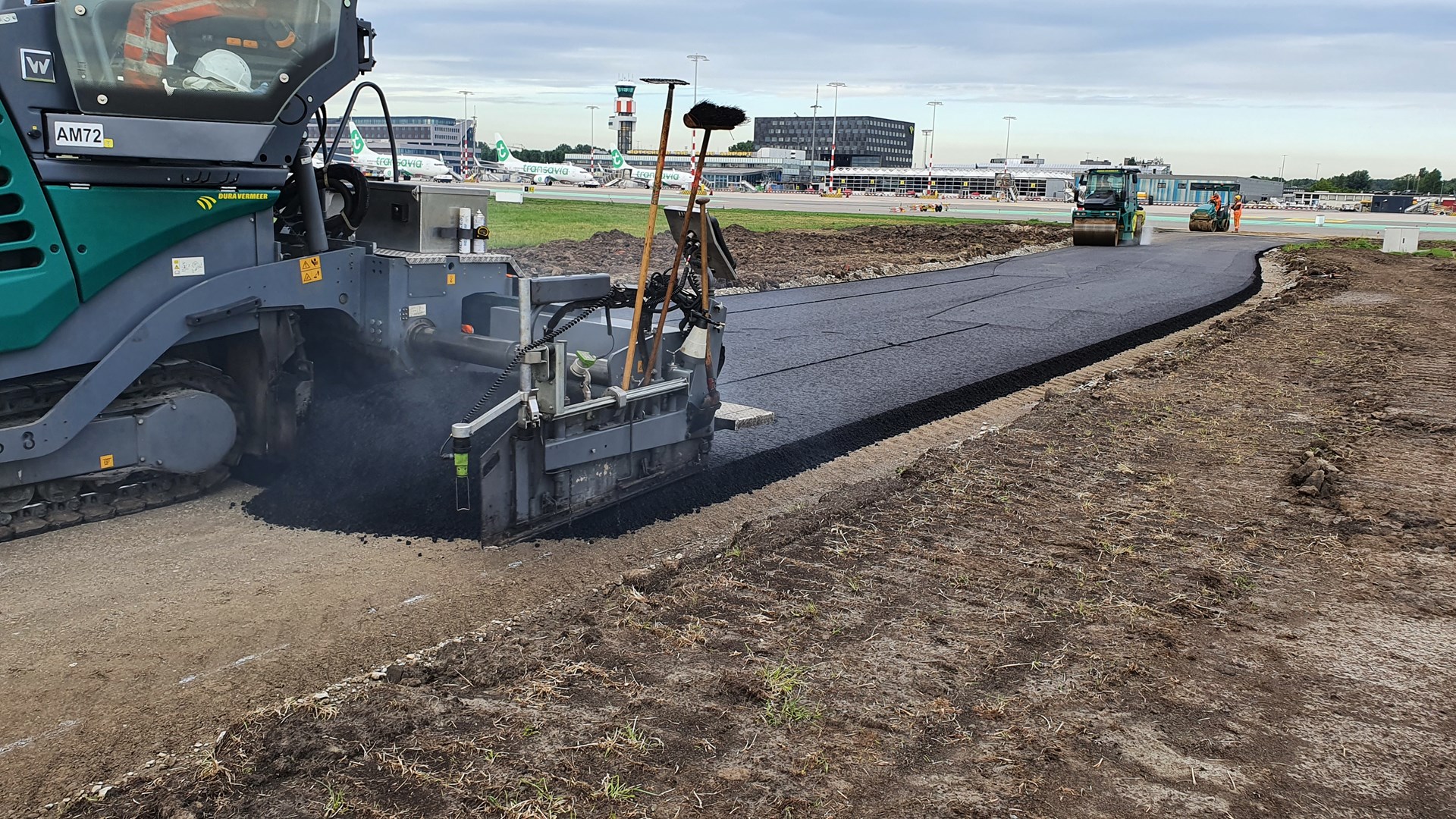 Machine asfalteert baan Rotterdam Airport met dakbitumen